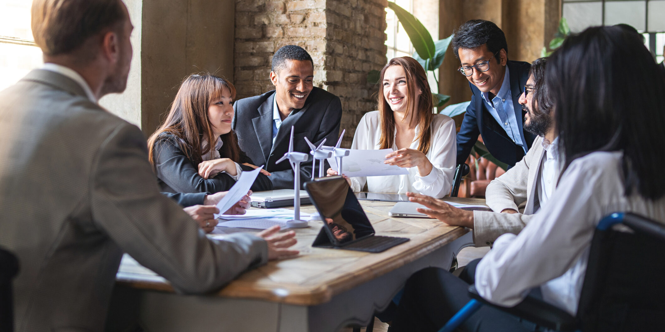 Group of multiethnic businesspeople discussing about financial strategy, renewable power, sustainable innovation project and environmental economical issues - business, sustainability interracial lifestyle concept