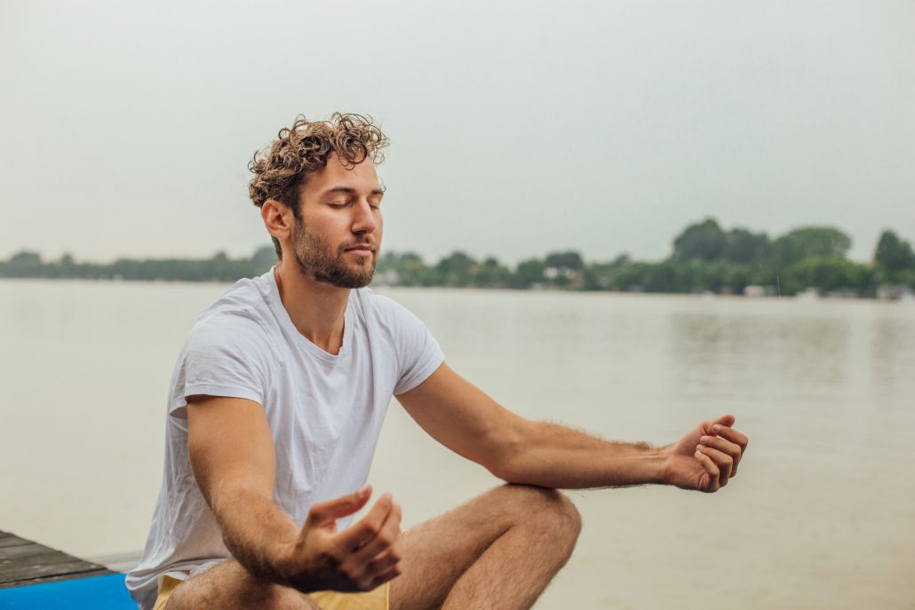 Young man doing yoga outdoors