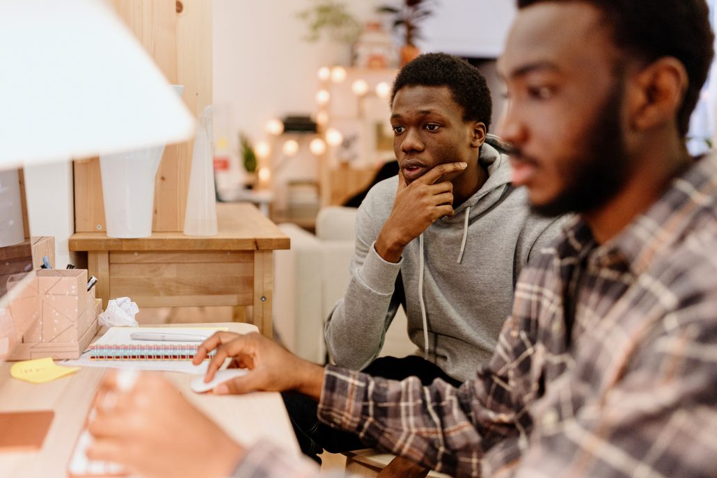 African American students working on a computer for a university project at home