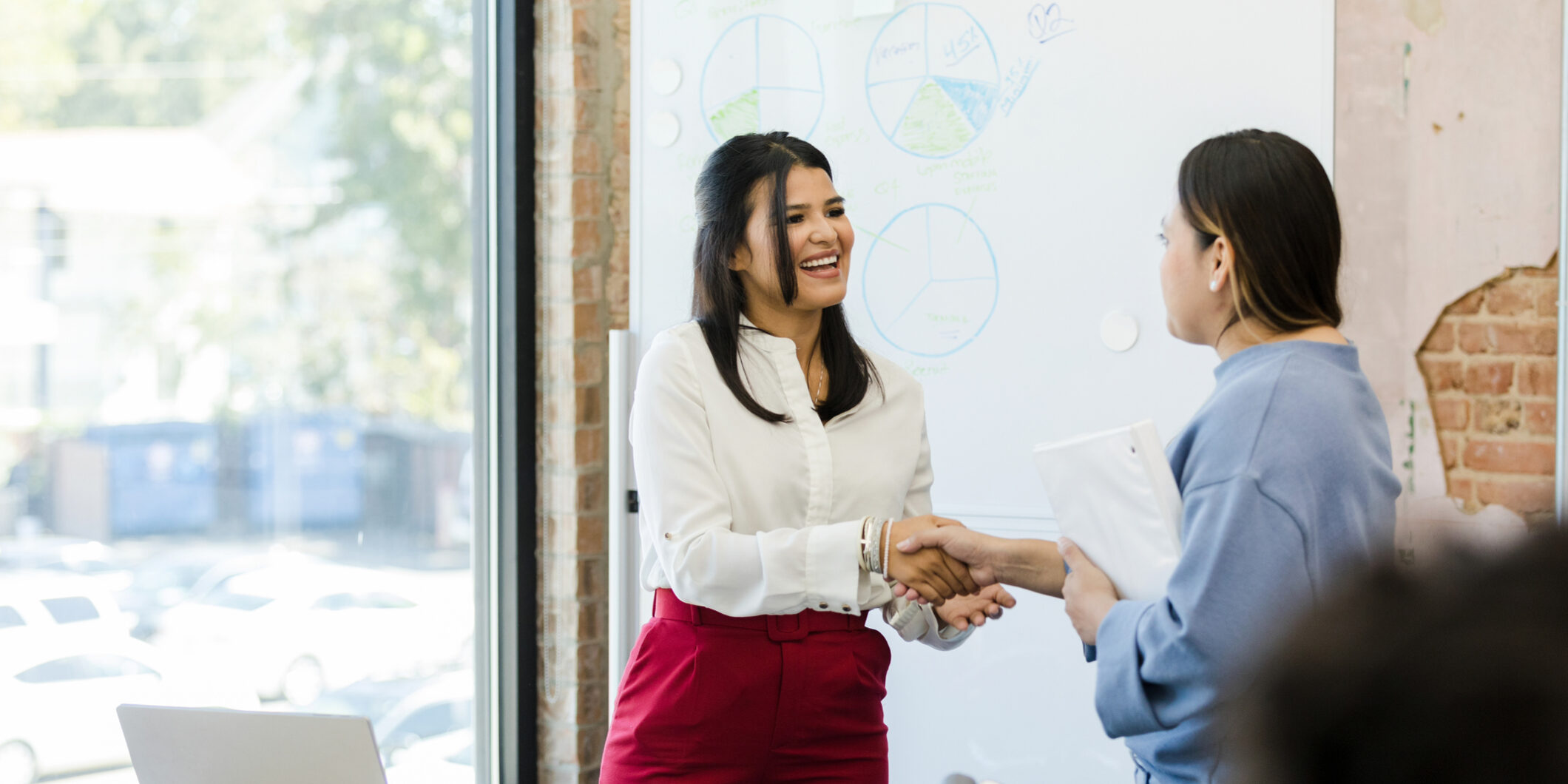 Female CEO shakes hands with female employee