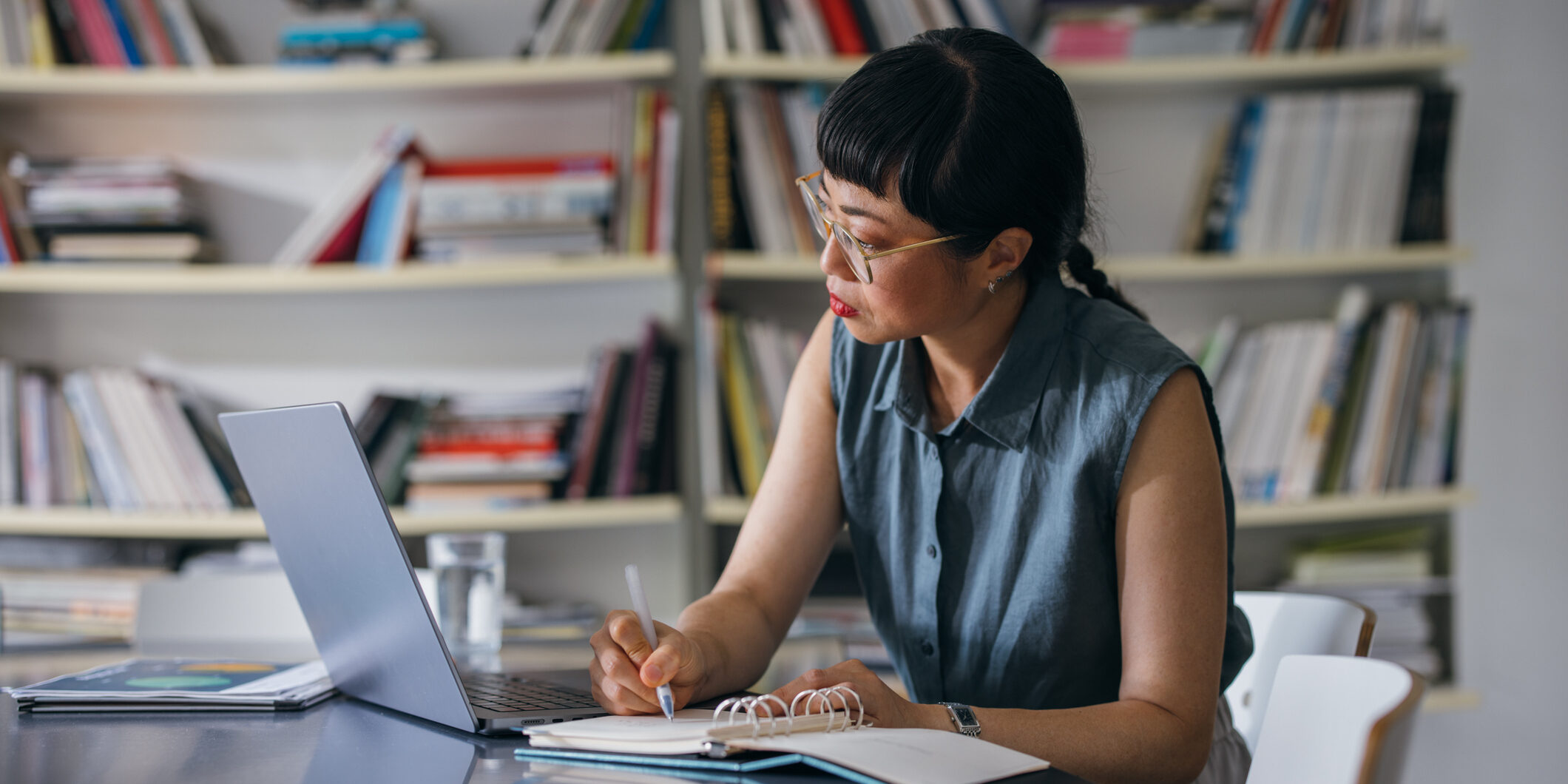A Beautiful Asian Businesswoman With Glasses Using Her Computer While Working In The Office